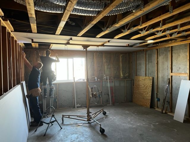 Hanging ceiling drywall in a basement remodel