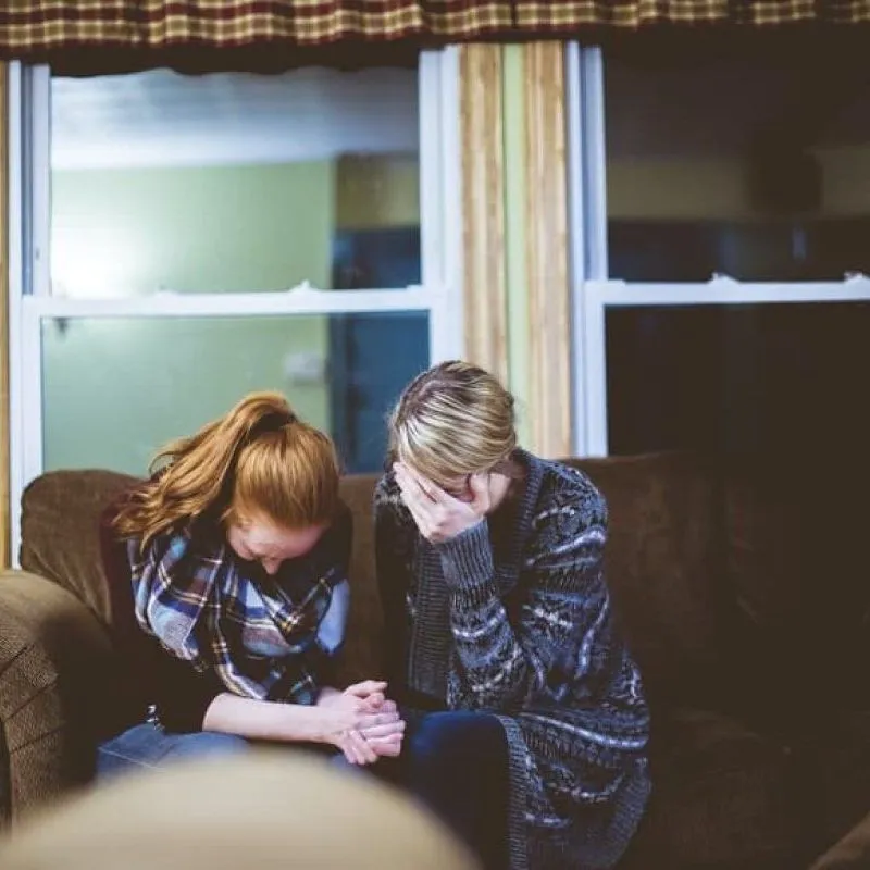 Two women comforting each other after a traumatic event